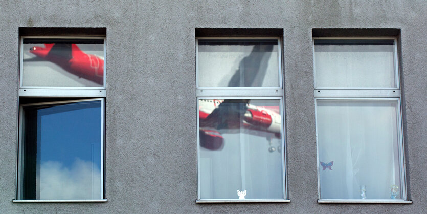 Ein Flugzeug spiegelt sich in einem Fenster