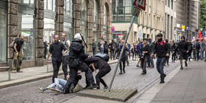 Polizisten verprügeln einen am Boden liegenden Mann