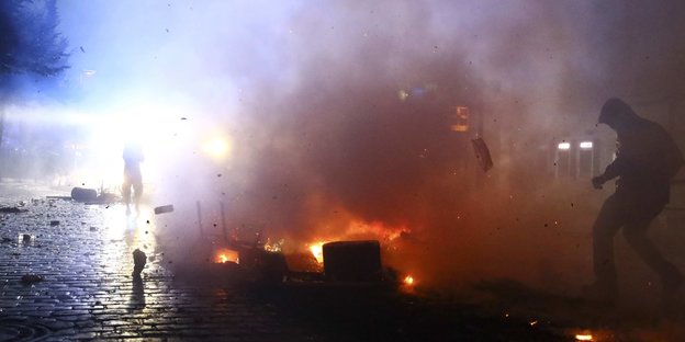 Eine Szene mit Feuer, Rauch und Menschen aus dem Hamburger Schanzenviertel