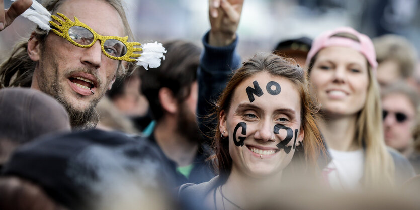 Drei Menschen bei einer Anti-G20-Demo