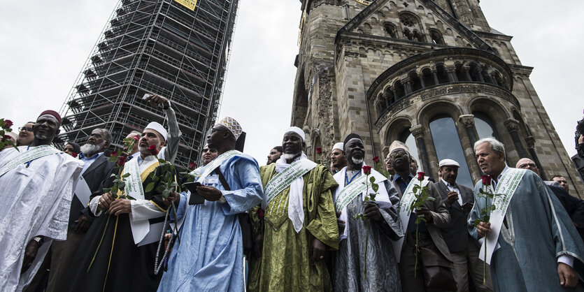 Mehrere Männer stehen vor der Gedächtniskirche