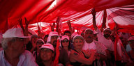 Eine Menschenmenge unter einem großen roten Tuch