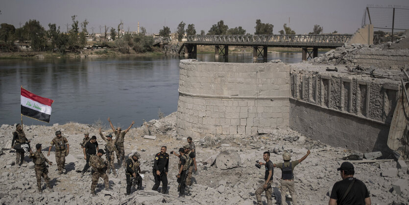 Jubelnde Soldaten an einem Fluss