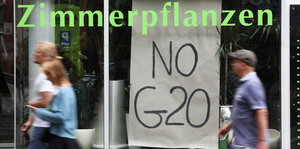 Ein Schaufenster mit dem Schriftzug "Zimmerpflanzen", darunter ein Schild mit "No G20"