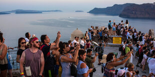 Viele Touristen am Meer, sie machen Fotos und gucken in die Ferne