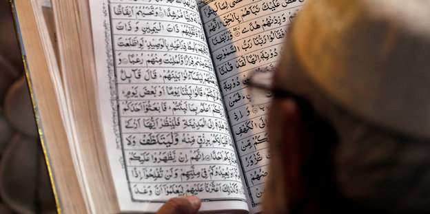 Ein Mann liest im arabischsprachigen Koran