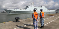 Zeri Hafenbearbeiter beobachten ein Militärschiff