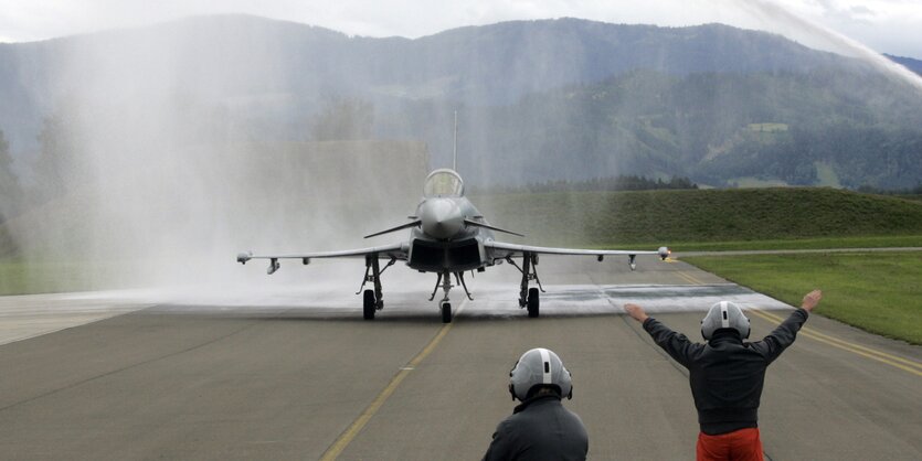 Ein Eurofighter auf der Landebahn mit Fluglotsen