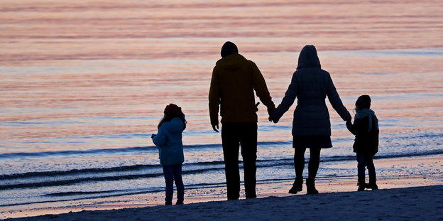 Eine Familie steht am Strand