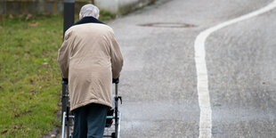 Eine Person mit Rollator läuft auf der Straße