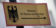 Ein Zettel mit einem Pfeil und der Aufschrift "Bundesamt für Migration und Flüchtlinge"