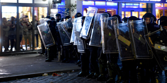 Polizisten stehen vor einem Geschäft