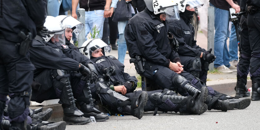 Polizisten sitzen am Straßenrand