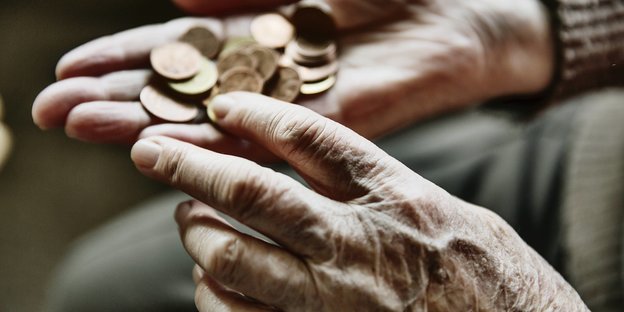 Geldmünzen in den Händen einer älteren Frau