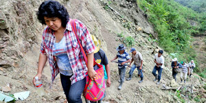 Eine Gruppe von Menschen steigt einen Berg hoch. Ganz vorn eine Frau. Es ist Berta Cáceres