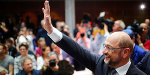 Martin Schulz hebt seine Hand zum Winken und lacht