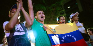Junge Menschen mit einer venezolanischen Flagge protestieren gegen die Pläne von Präsident Maduro