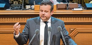 Mann im Anzug hält eine Rede vor Mikrophonen in der Hamburger Bürgerschaft