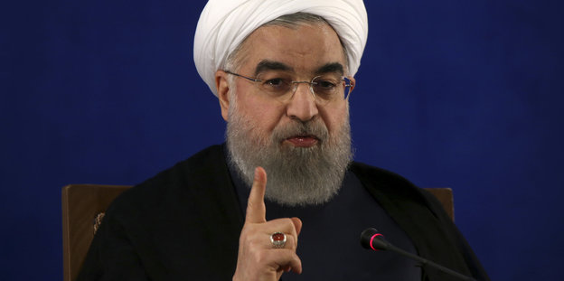 Mann mit Turban, Brille und erhobenem Zeigefinger - es ist der iranische Präsident Hassan Ruhani
