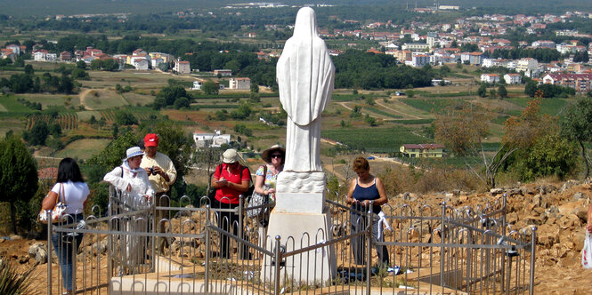 Marienstatue auf Berg, Touristen