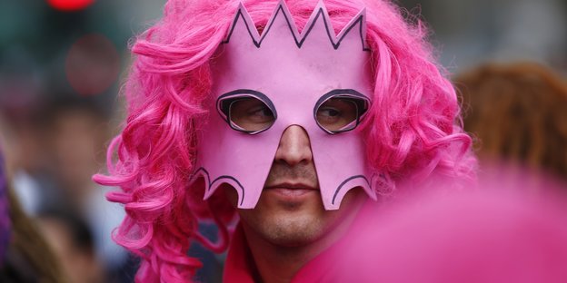 Ein Mann trägt eine pinke Perrücke und eine pinke Maske mit Krone auf dem G20-Gipfel-Protest