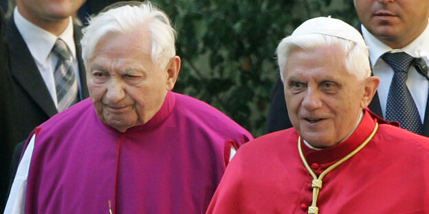 Zwei alte Männer mit rotem und violettem Gewand und christlichem Schmuck