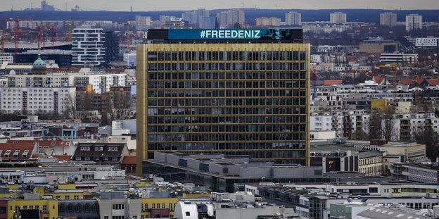 An der Fassade eines Hochhauses steht „Free Deniz“