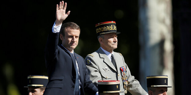 Emmanuel Macron und der ehemalige Generalstabschef Pierre de Villiers sitzen nebeneinander auf einem Wagen