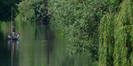 Stocherkahn fährt in Tübingen an grünen Weiden vorbei