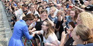 Kate Middleton steht vor ihren Fans am Brandenburger Tor, nur ein Metallzaun trennt sie von einander.