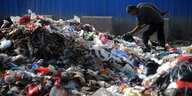 Ein Müllsammler in Qingdao guckt in den Müll