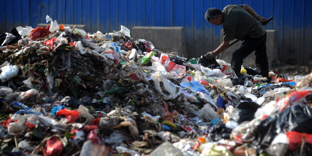 Ein Müllsammler in Qingdao guckt in den Müll