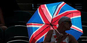 Eine Person hält einen Regenschirm, der aussieht, wie eine britische Flagge