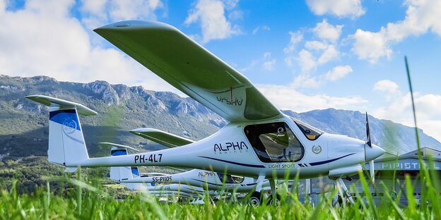 Drei Flugzeuge stehen auf einer Wiese nebeneinander. Drei Flugzeuge stehen auf einer Wiese nebeneinander.