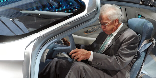 Ein Mann, Winfried Kretschmann, sitzt in einem Auto