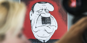 Eine Karikatur, auf der Erdogan die Verfassung als Hitlerbärtchen trägt