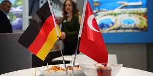 Eine deutsche und eine türkische Flagge auf einem Tisch mit Häppchen