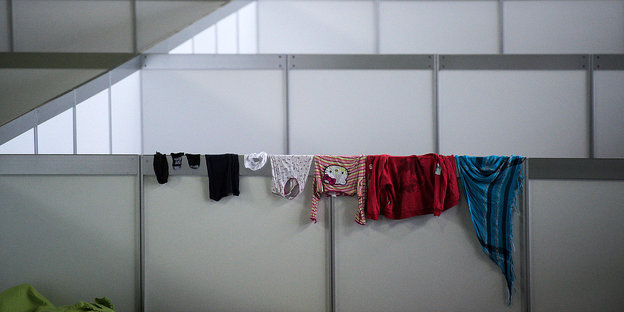 Kinderwäsche hängt über den Abtrennungswänden einer Flüchtlingsunterkunft