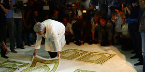 Eine Frau legt ihren Gebetsteppich aus