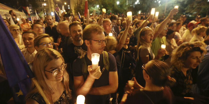 Menschen demonstrieren nachts mit Kerzen