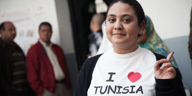 Eine Frau trägt ein T-Shirt, auf dem auf Englisch „Ich liebe Tunesien“ steht