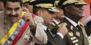 Maduro macht eine Geste, während er vor Militärs steht