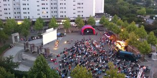 sicht von oben auf einen Platz mit Menschen und Kino-Leinwand