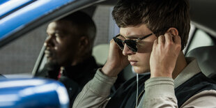 Baby (Ansel Elgort) und Bats (Jamie Foxx) in einem blauen Auto.