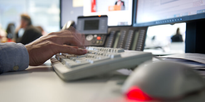 Jemand tippt auf einer Computer-Tastatur