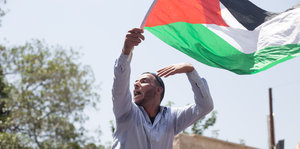 Mann schwenkt die palästinensische Fahne