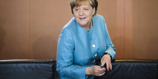 Angela Merkel, eine Frau mit kurzen Haaren in einem blauen Anzug