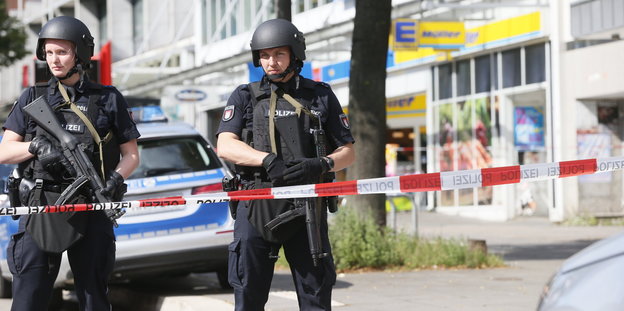 Einsatzkräfte der Polizei sperren nach einer Messerattacke in einem Supermarkt in Hamburg den Tatort ab.