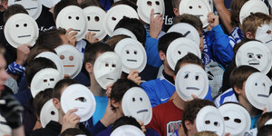 Menschen halten weiße Masken vor ihren Gesichtern