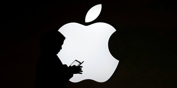 Die Silhouette einer Person vor einem Apple-Logo